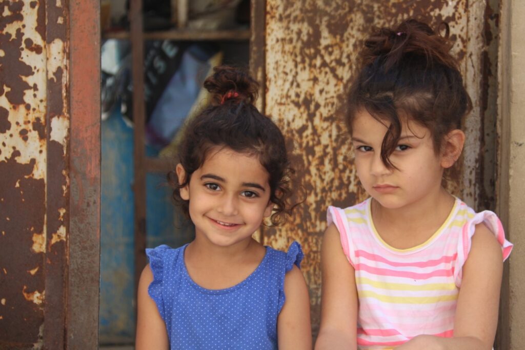 نظرة وابتسامة من طفلتان في مخيم البص في صور، جنوب لبنان (بعدسة رانية سعد الله).