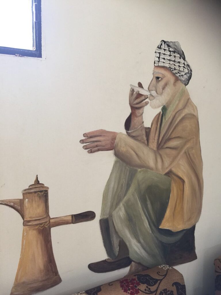 لوحة جدارية لرجل فلسطيني يشرب القهوة في مضافته الصورة في مركز الامل للمسنين في عين الحلوة بعدسة (رشا حيدر)