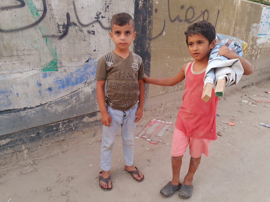 طفلان يلهوان في أحد أزقة حي جار القمر في مخيم نهر البارد للاجئين الفلسطينيين في مدينة طرابلس، شمال لبنان (بعدسة عدنان الحمد)