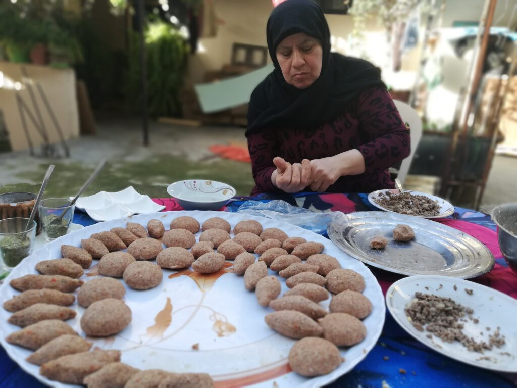 الحاجة ام صالح تقوم بتحضير الكبة في الهواء المطلق في مخيم عين الحلوة للاجئين الفلسطينيين ، صيدا ، جنوب لبنان (بعدسة رشا حيدر)