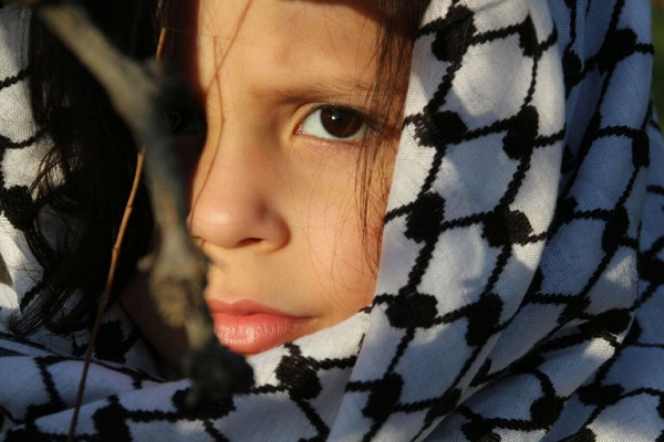 طفلة من مخيم الرشيدية في صور جنوب لبنان، تضع الكوفية الفلسطينية على رأسها وتغطي بها شعرها (بعدسة رانية سعد الله).