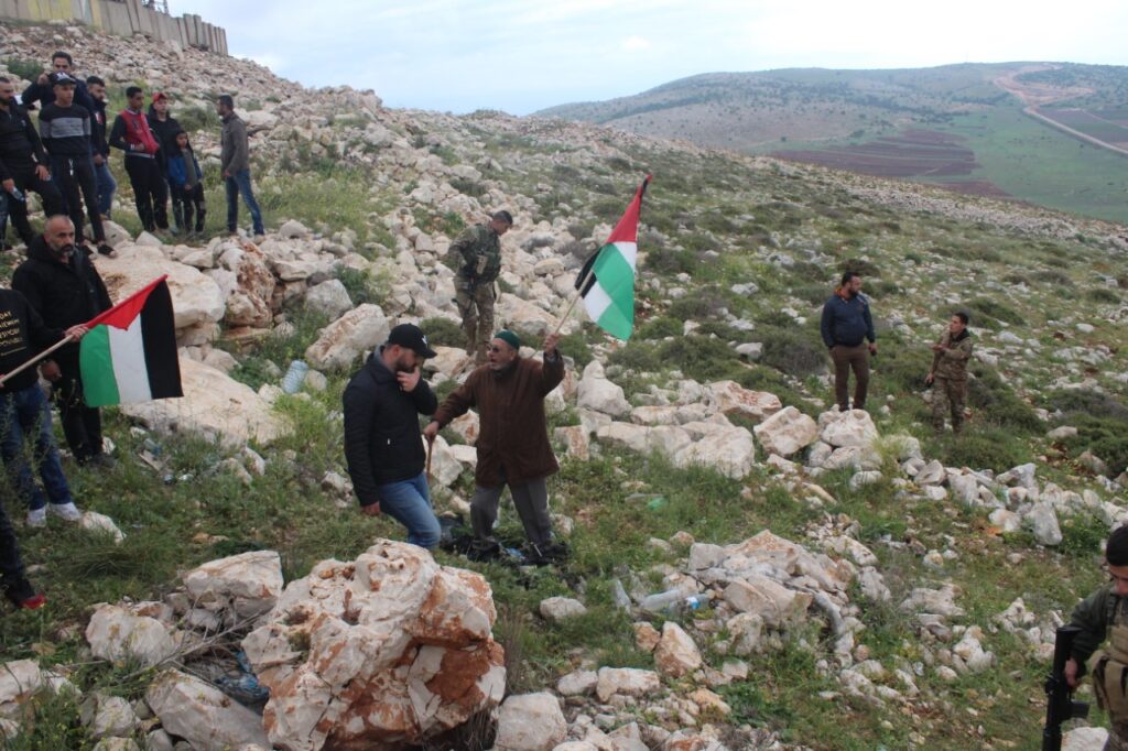 حاج فلسطيني يرفع علم فلسطين خلال مشاركته في مسيرة العودة في منطقة مارون الراس جنوب لبنان ( بعدسة محمد فيصل محمود)