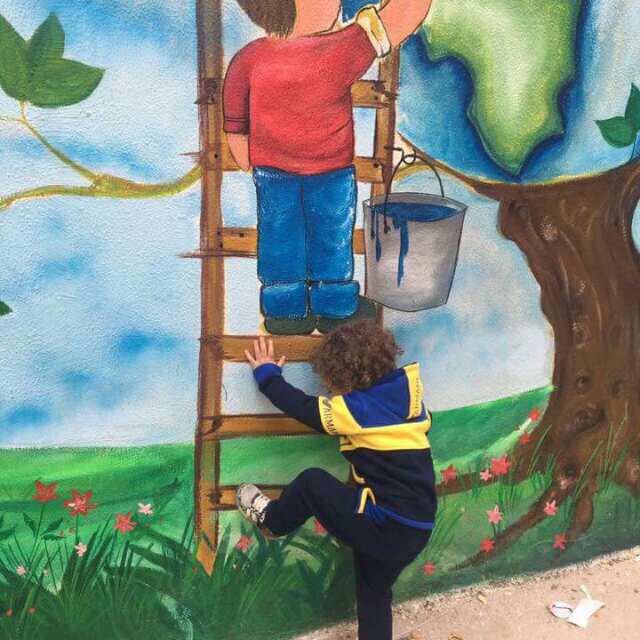 طفل يحاول صعود السلم المرسوم على أحد جدران حي جاحولا في مخيم نهر البارد شمال لبنان، ظنّ انه سلماً حقيقياً (بعدسة عدنان الحمد)