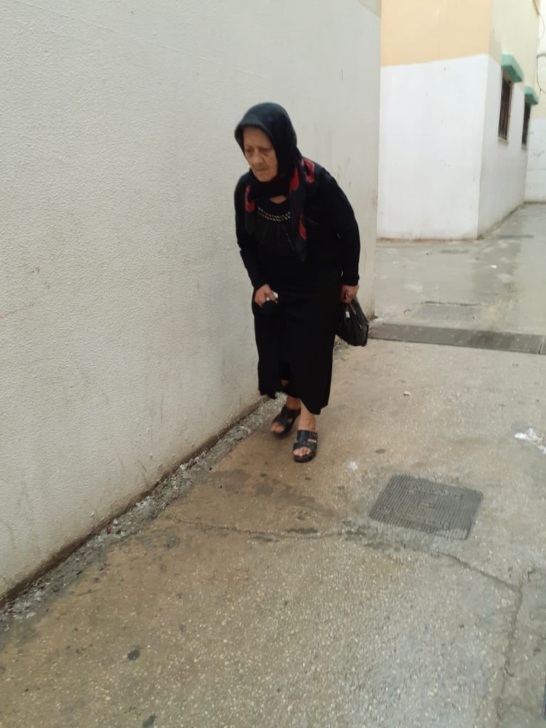 سيدة مسنة في طريقها الى السوق لشراء حاجياتها في مخيم نهر البارد للاجئين الفلسطينيين في طرابلس، شمال لبنان (بعدسة عدنان الحمد)