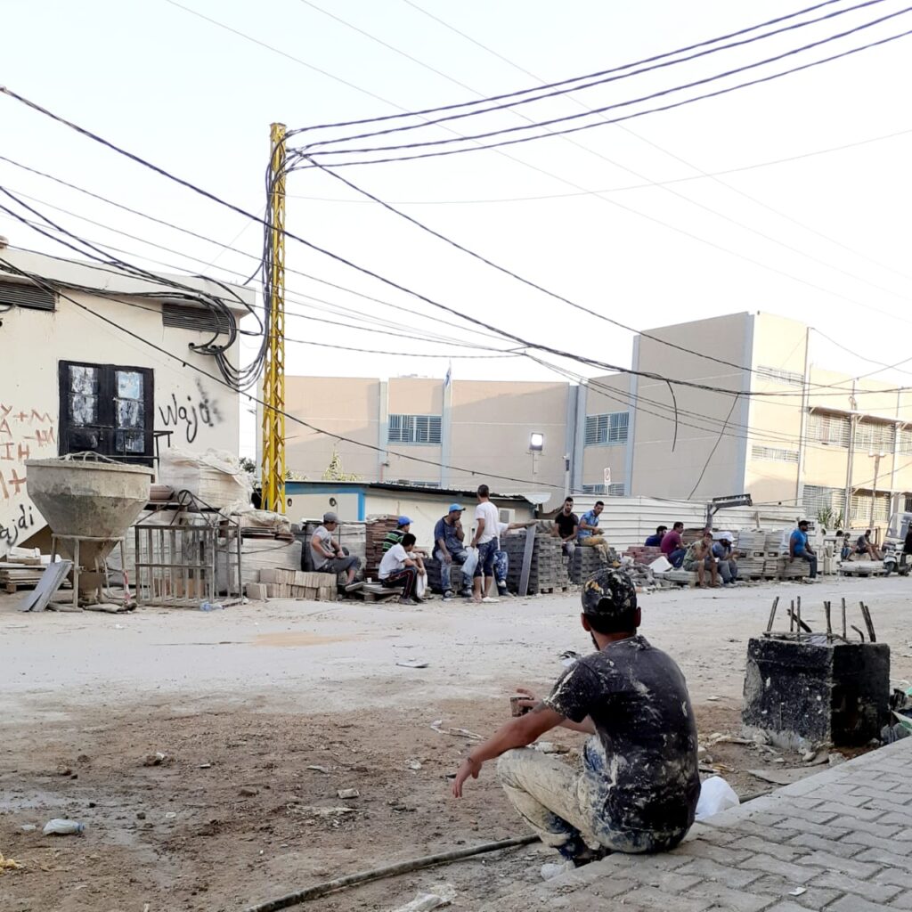 عمال يعملون في اعادة اعمار مخيم نهر البارد للاجئين الفلسطينيين في استراحة صباحية قبل مباشرة عملهم (بعدسة عدنان الحمد)