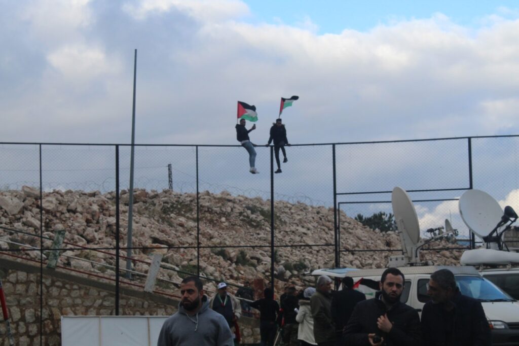 شبان يرفعون علم فلسطين على السياج الشائك خلال مسيرة العودة في منطقة مارون الراس جنوب لبنان ( بعدسة أنس العلي).