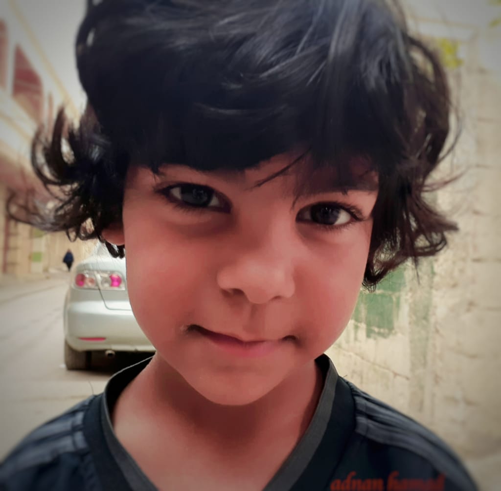 طفل استوقفته عدسة “شبابيك” في شارع المجلس في مخيم نهر البارد للاجئين الفلسطينيين في طرابلس، شمال لبنان (بعدسة عدنان الحمد)