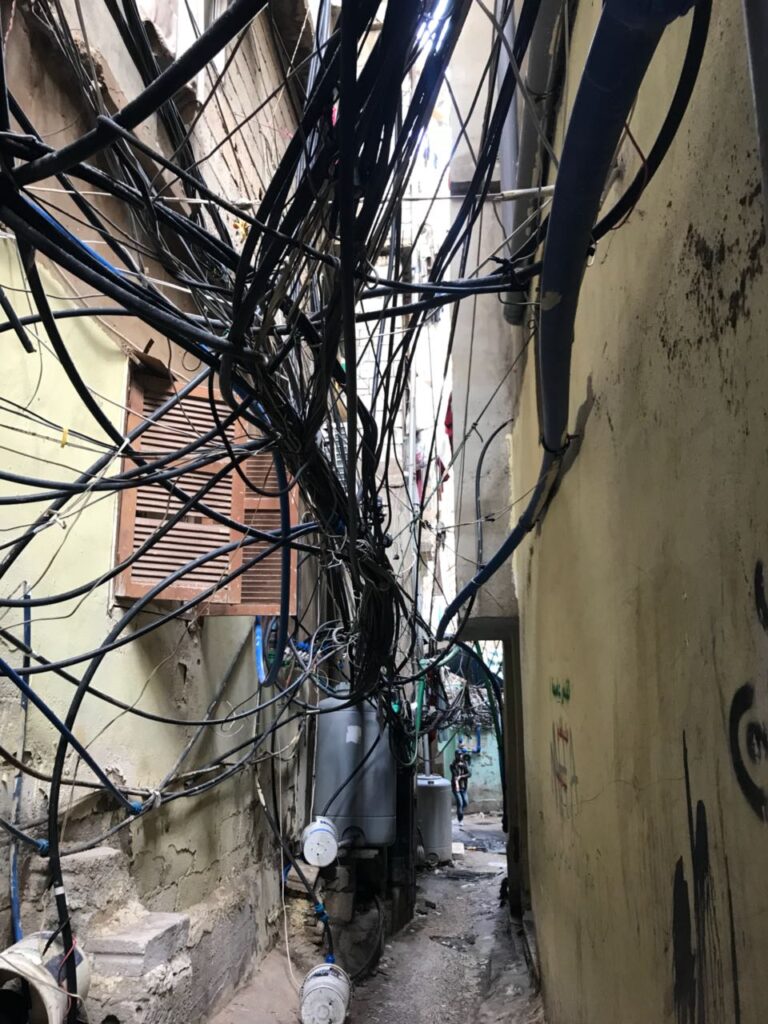 أشرطة الكهرباء في أحد أزقة مخيم برج البراجنة في الضاحية الجنوبية من بيروت، والتي تُعتبر من المشاكل الاساسية وتحصد العديد من الأرواح سنوياً (بعدسة لميس ياسين).