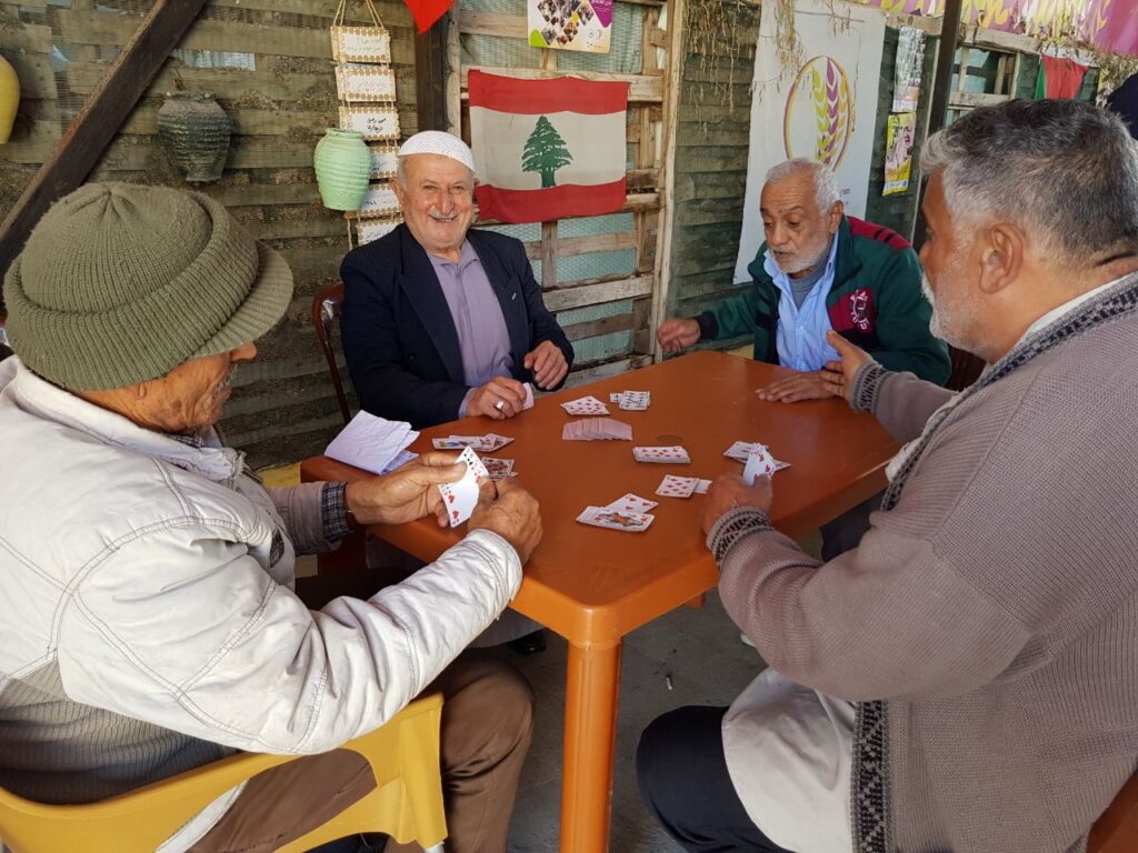 مجموعة من الرجال يلعبون الورق في مخيم الرشيدية في صور، جنوب لبنان، ضمن برنامج سنابل  التابع لمركز البرامج النسائية الذي يهدف لدمج المسنيين بالمجتمع وتعزيز قدراتهم داخل منازلهم (بعدسة ربا رحمة)